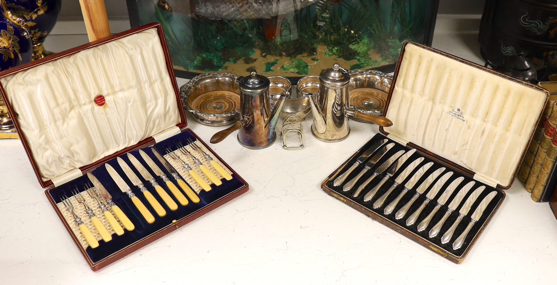 A case of twelve silver handled tea knives, one damaged, Sheffield 1931, two pairs of silver plated wine coasters including 19th century, a plated cafe au lait pair and two other plated items.